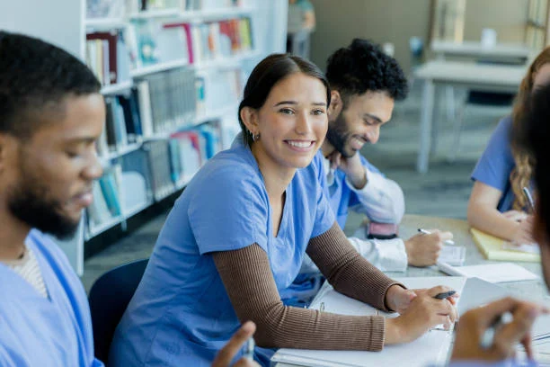Graduate nurse studying for the NCLEX RN examination while working toward the minimum passing standard needed to begin a nursing career